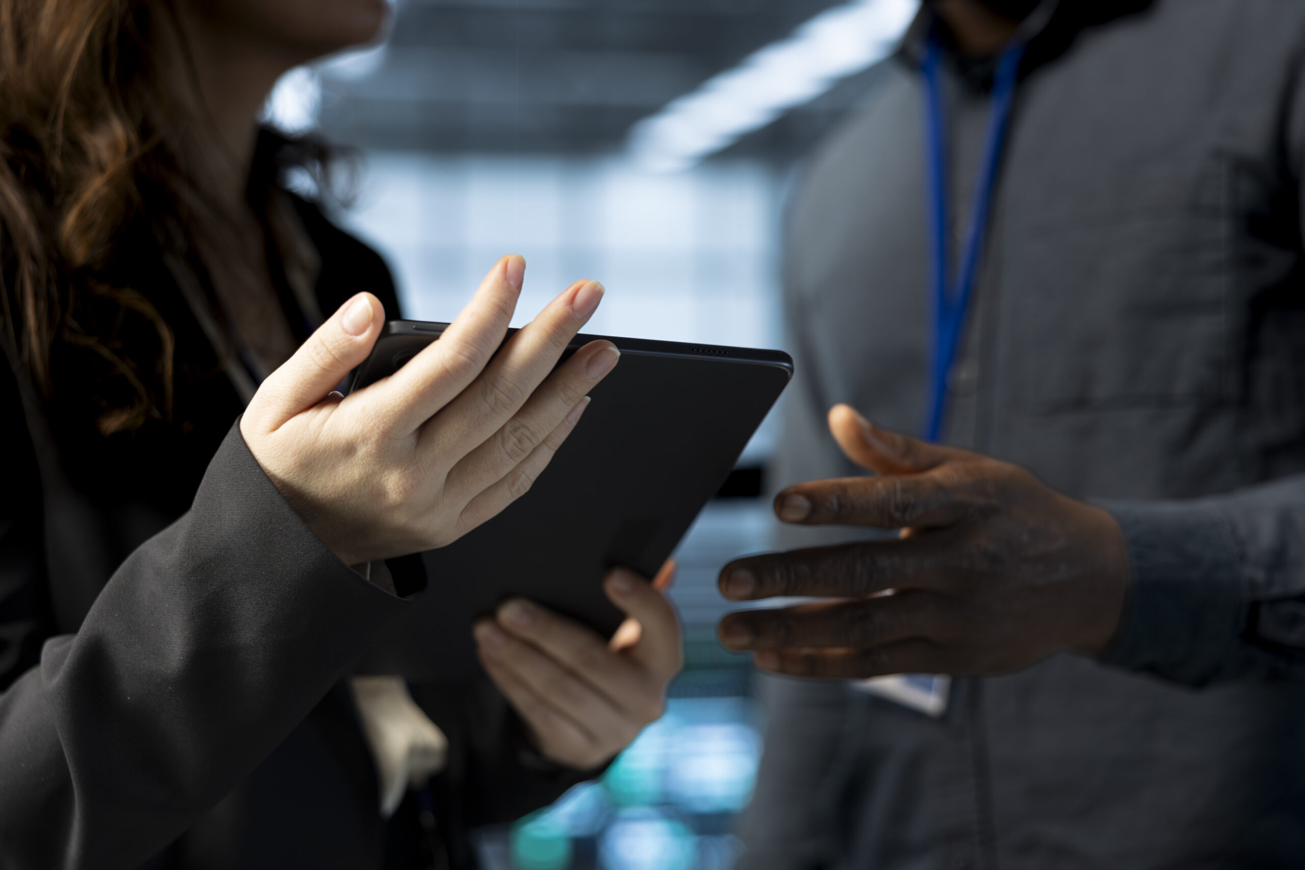 Teamworking data center admins using laptop, conducting security audits, preventing vulnerabilities. Close up of IT staff members using device to review firewall rules, logging incident details